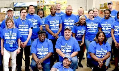 Volunteers wearing a blue Sam's Club Day of Service t-shirts and posing for a group photo.