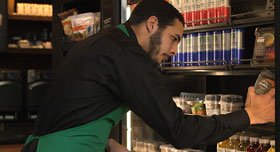 A Starbucks employee collecting food to be donated.