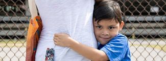 Boy hugging his mother at a mobile food pantry