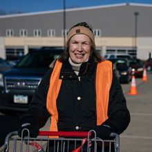 Janet wearing an orange safety vest while volunteering at a holiday meal distribution