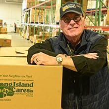 Long Island Cares CEO Paule Pachter leaning on box