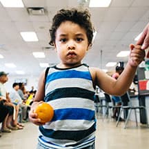 Juan Alfredo, 2, eats an orange at a summer meals program in Phoenix, Arizona.