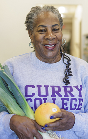 A volunteer holding vegetables and fruits