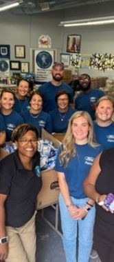 A group of people wearing blue shirts and posing for a photo.