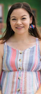 A young woman kneels outside a food bank.
