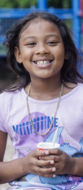 Aneah sitting on a swing at a park.