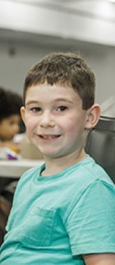 Tristan sitting at a table and eating lunch.
