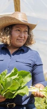 Maxi Hernandez holding produce on her farm