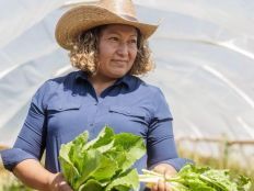 Maxi Hernandez holding produce on her farm.