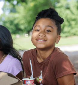 A smiling young girl with having a snack