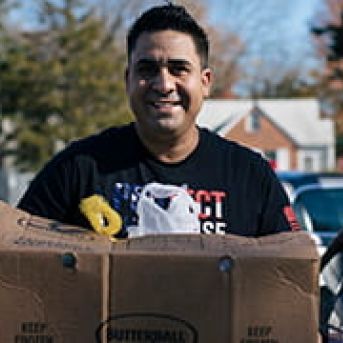 Edgar holding a box of food he received from the food bank after returning home from active duty