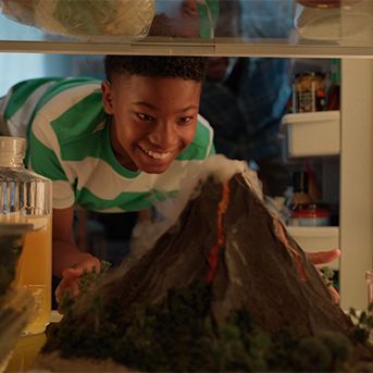 Child looking to a fridge and seeing a science fair project