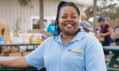 A food bank worker at an outdoor food distribution location.