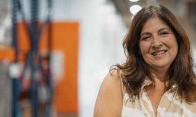 Mary Jo standing in a food bank warehouse.