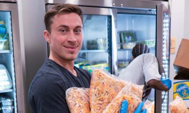 A volunteer holding bags of food.
