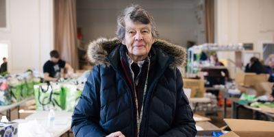 An elderly woman at a food distribution location.