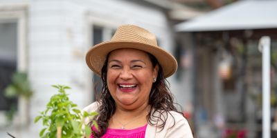 Woman smiling, working in her garden.
