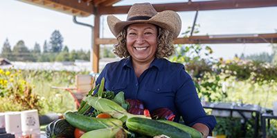 Maxi holding a crate of vegetables.