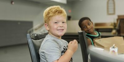 Cooper eating breakfast at a school table. 