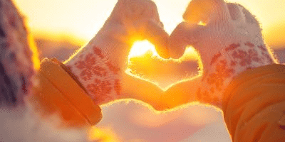hands in a heart shape with winter gloves