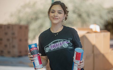 Volunteer holding canned food.