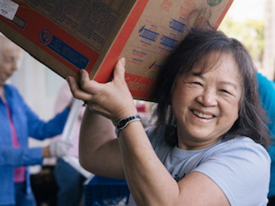 Food pantry worker carrying a box of food in Yorba Linda, California