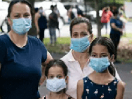 A family of four wearing masks