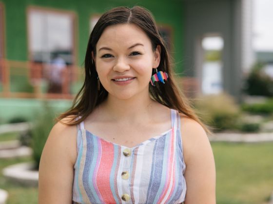 A young woman kneels outside a food bank