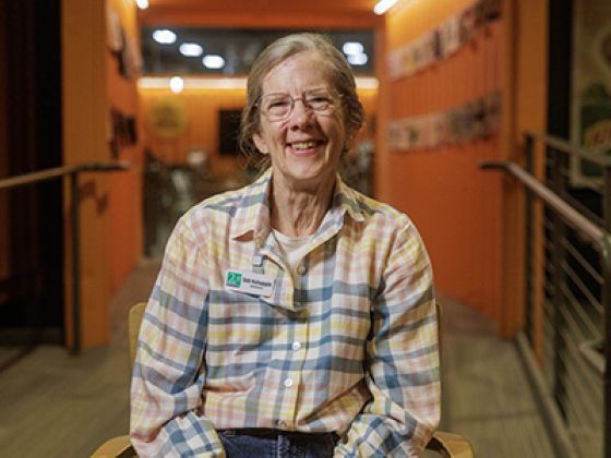 Deb sitting on a chair while smiling.