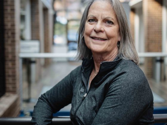 Kat smiling while sitting on a bench.