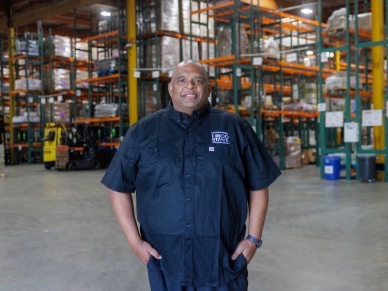 Terrance standing in a food bank warehouse.