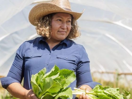 Maxi Hernandez holding produce on her farm