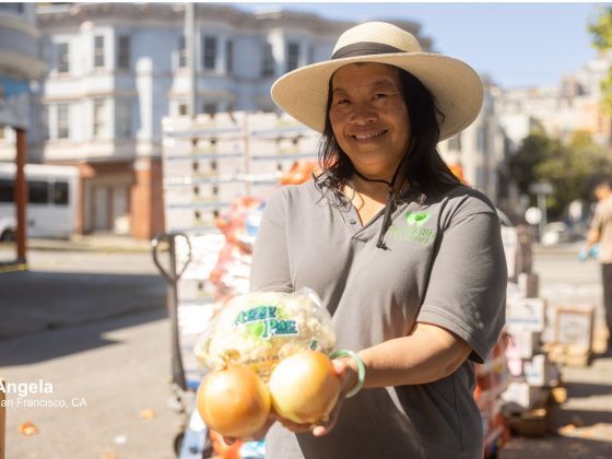 Angela holding produce.