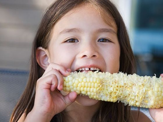 Girl eating corn.