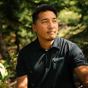 Jesse sits on a bench near 'Elepaio Social Services.