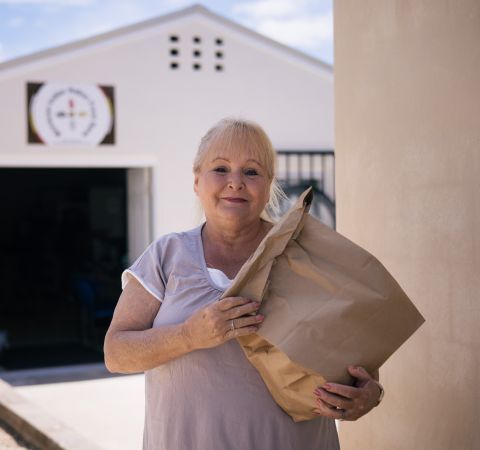 Photo of an elderly woman with a food bag.