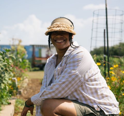 A woman smiling in a garden.