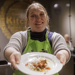 A woman holding a plate of food.