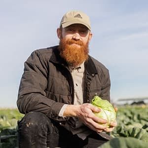 Farmer Mike holds a cabbage.