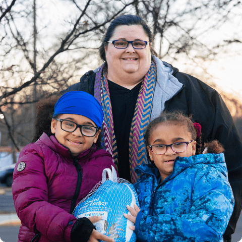 A mom and her two young children standing outside.