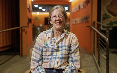 Deb sitting on a chair while smiling.