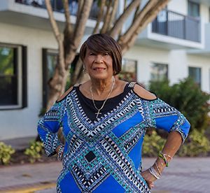 Mariela standing in front of an apartment building.