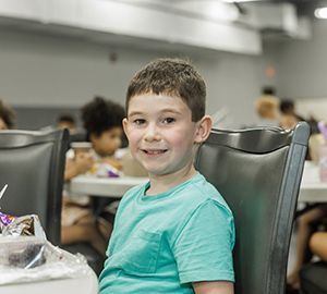 Tristan sitting at a table and eating lunch.
