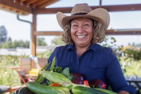 A farmer standing in front of fresh produce
