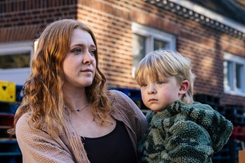 Taylor holds her son in front of a food bank