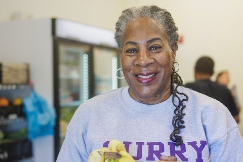 A smiling volunteer in a grey college shirt