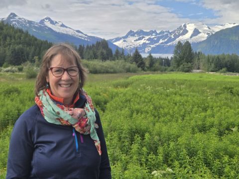 Judith Saxton pictured with scenery of Alaska in the background.