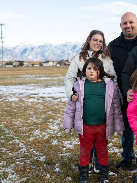 Kristy and her family standing in a field.