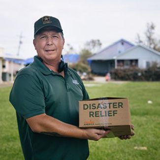 Food bank staff member holding disaster relief box.