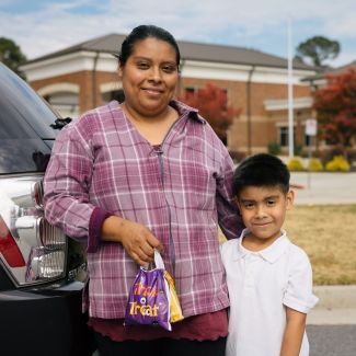 A mom and her son in front of a school.